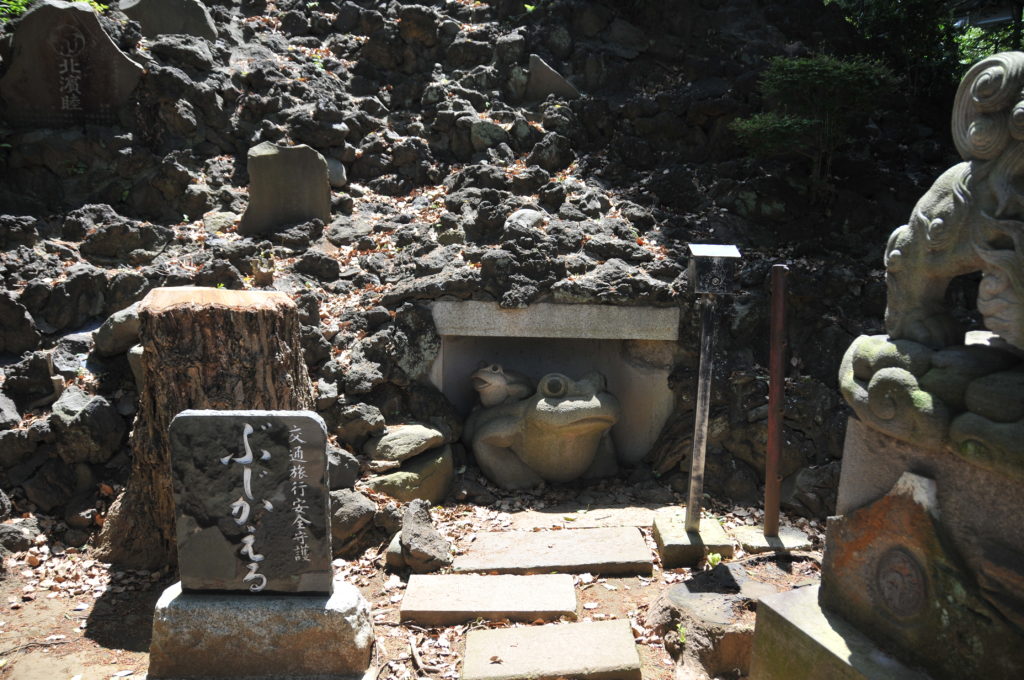 富士塚の麓の祠には「ぶじかえる」の大小2匹のカエルの石像