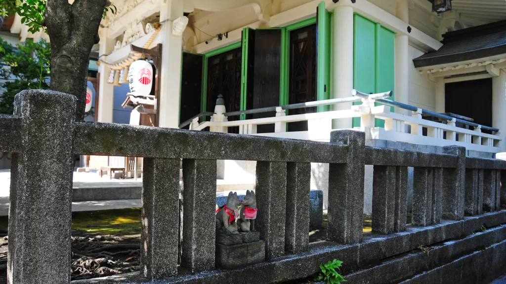 石柵にちょこんと座る眷属のお狐様